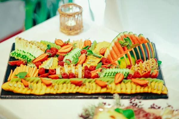 Tagliere di frutta fresca con anguria, ananas e frutti di bosco