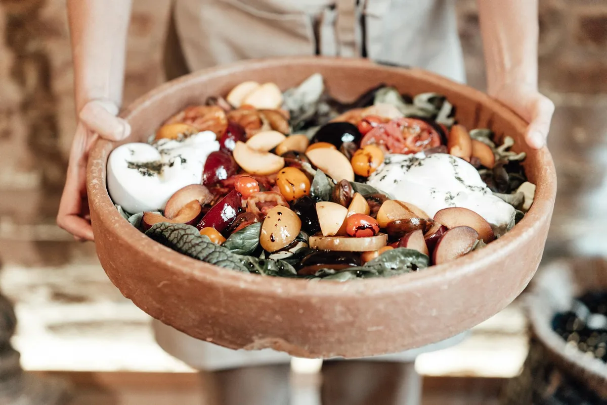 Salade rustique aux fruits frais, légumes verts et fromage dans un bol en bois