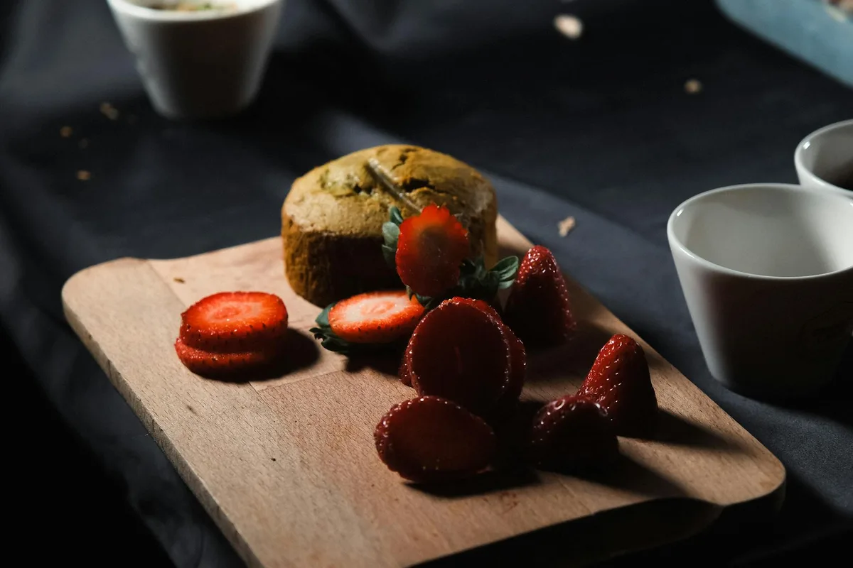 Plateau en bois avec fraises fraîches et dessert cuit au four sur table sombre