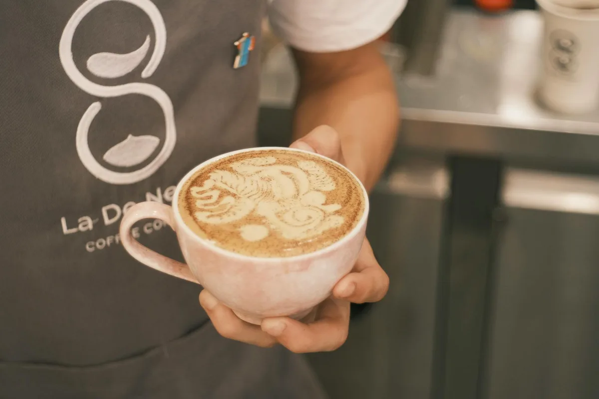 Primo piano barista con cappuccino e latte art