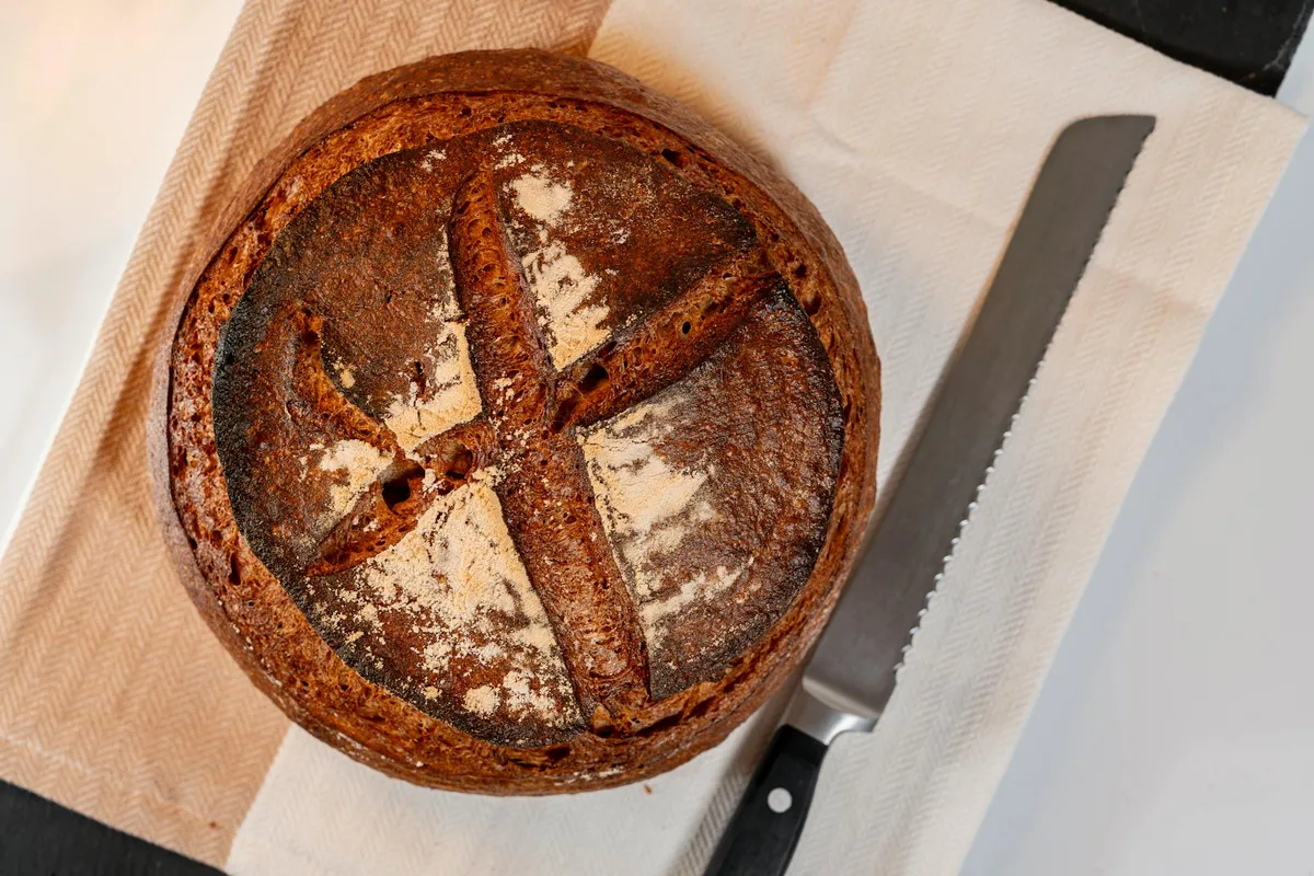 Primo piano di pane a lievitazione naturale artigianale con coltello
