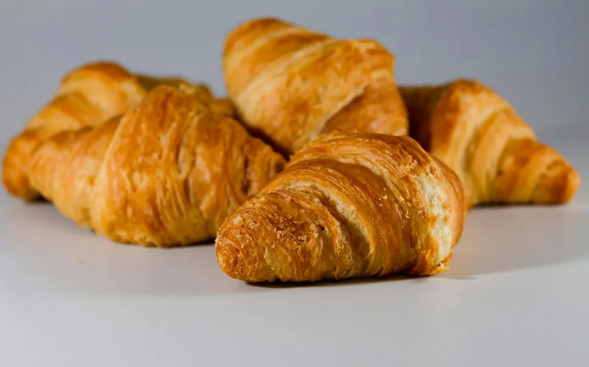 Gros plan de croissants feuilletés au beurre pour inspiration petit-déjeuner