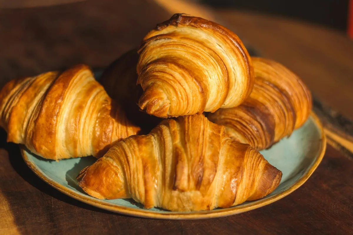 Gros plan de croissants dorés sur assiette pour imagerie petit-déjeuner