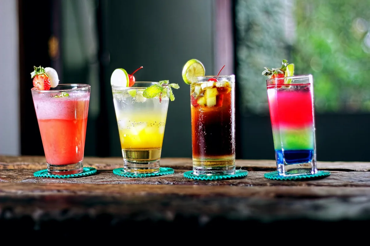 Assortimento colorato di cocktail su tavolo rustico in legno per serate estive