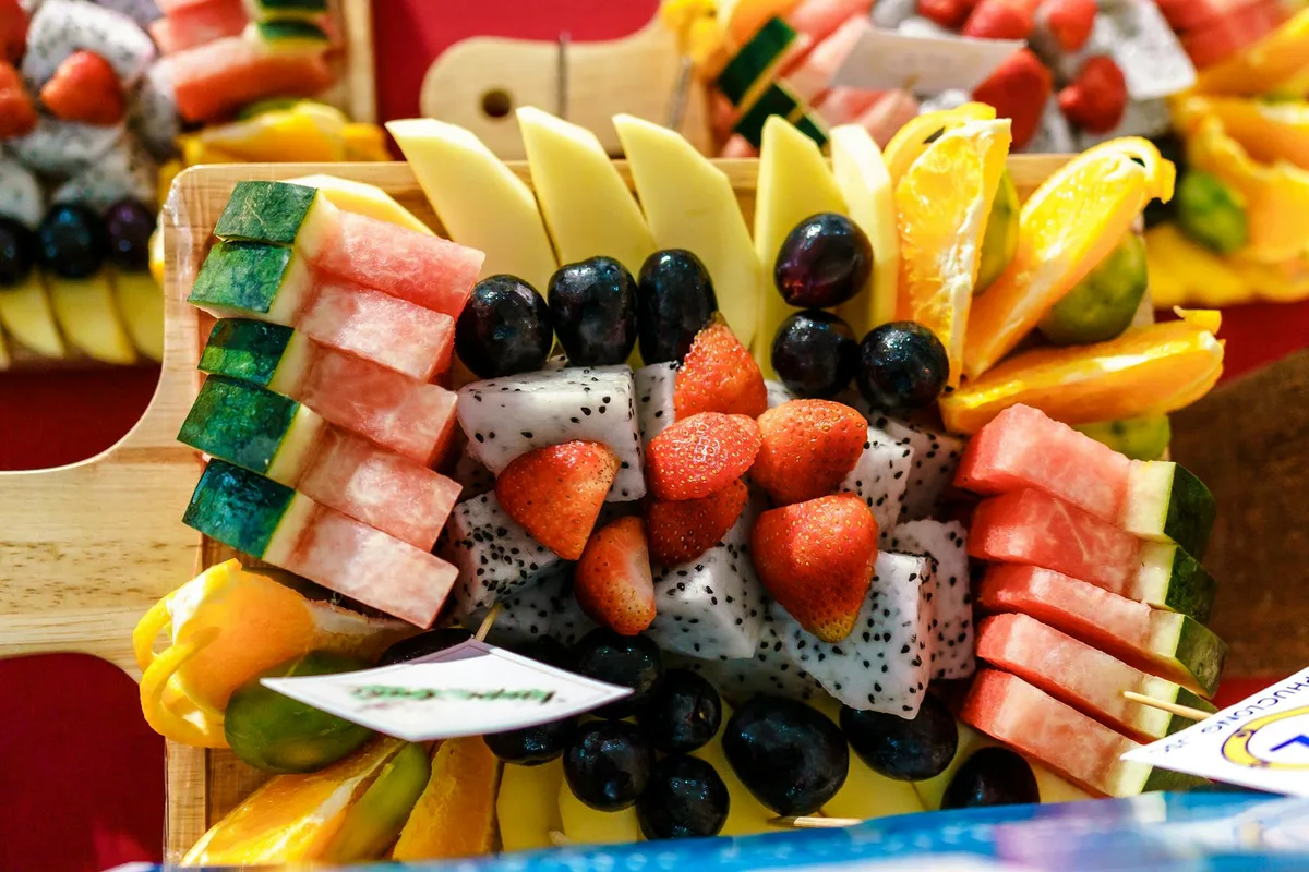 Bandeja de frutas coloridas com melancia, morangos, laranjas e mais, ideal para alimentação saudável