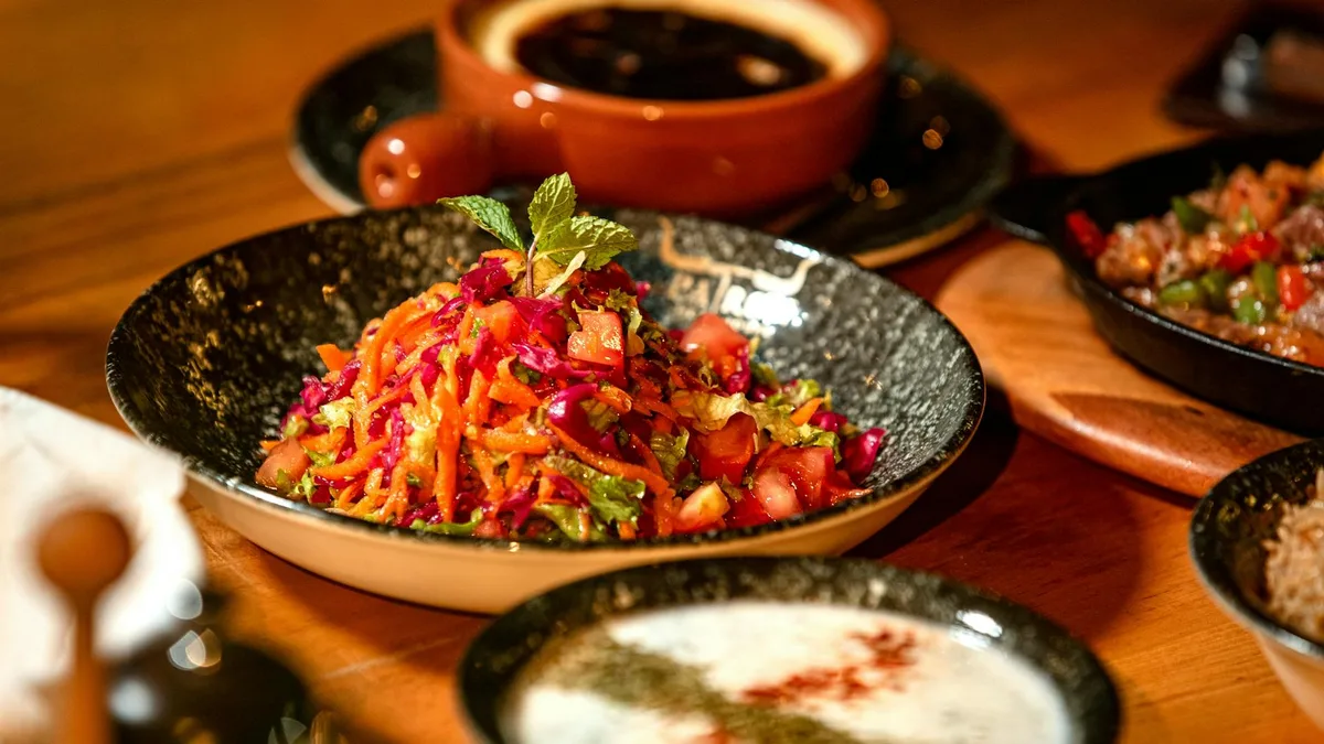 Insalata mista colorata su tavolo rustico con stoviglie assortite