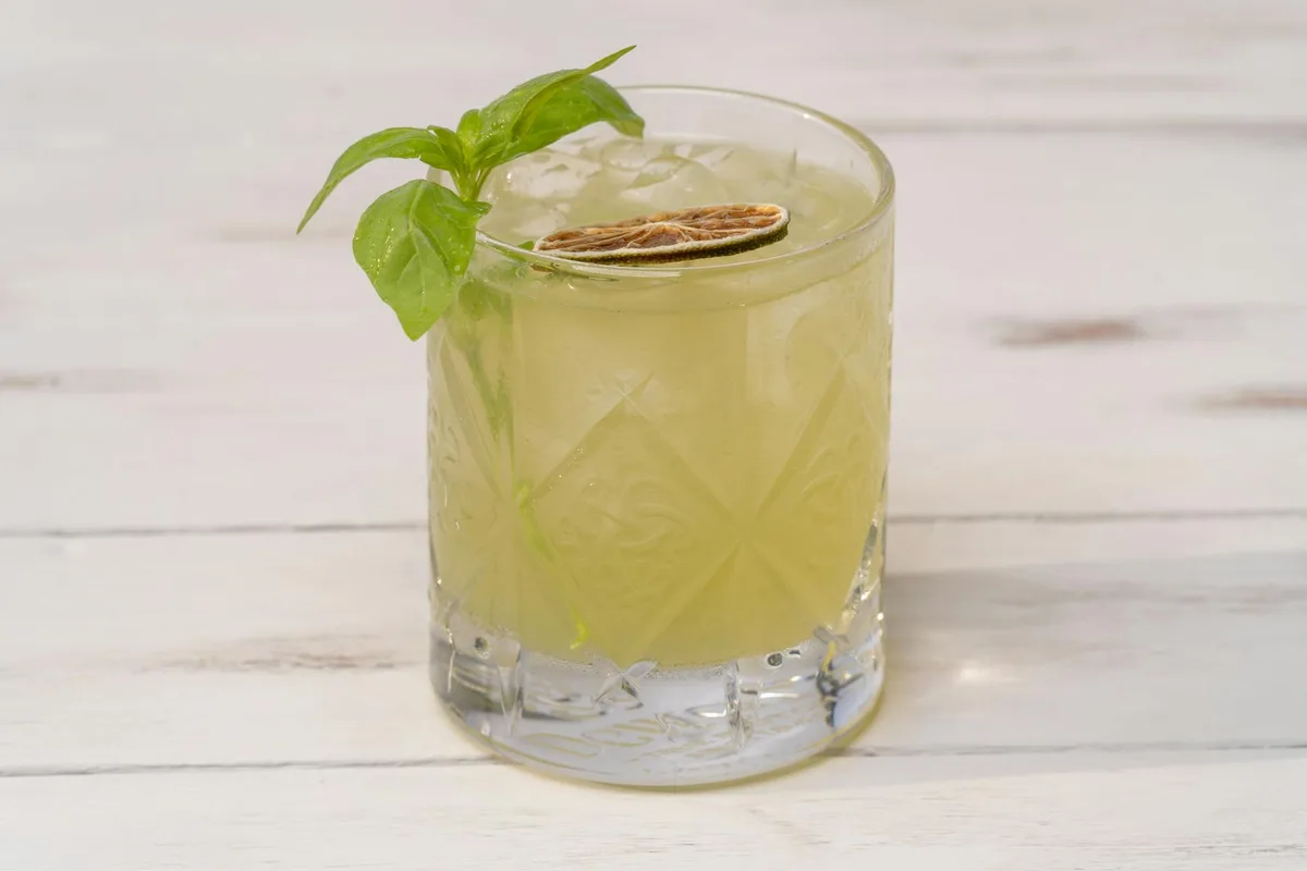 Cocktail al lime con menta in bicchiere decorato su tavolo di legno