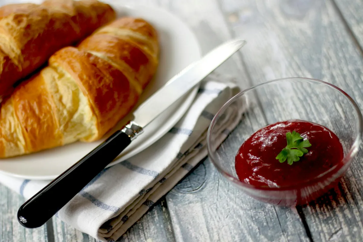 Köstliche Croissants mit einer Beilage Marmelade für ein perfektes Frühstück