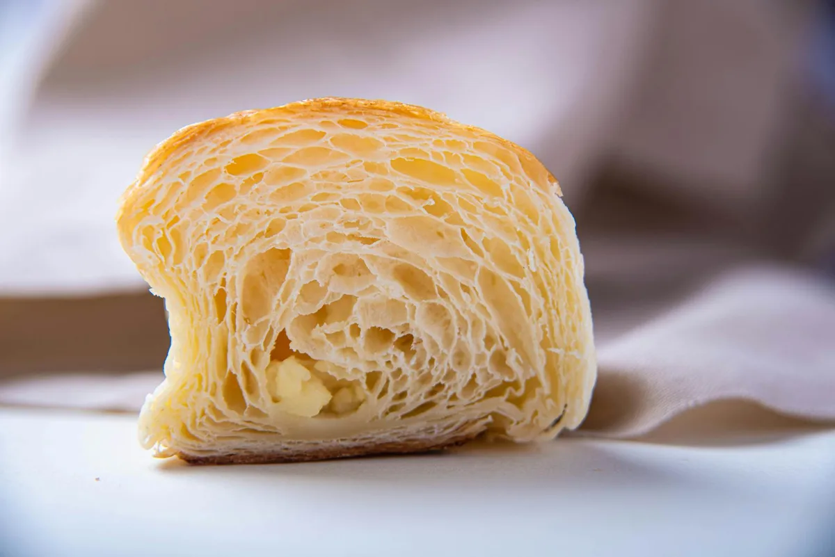 Gros plan d'une tranche de croissant fraîchement cuit, texture feuilletée et couches