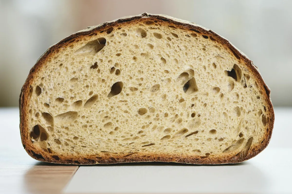 Close detalhado de fatia de pão artesanal sourdough exibindo textura e miolo