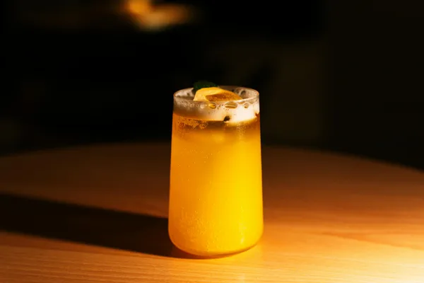 Elegantes Zitronencocktail-Glas mit Zitrusscheibe in Tokioter Bar-Atmosphäre