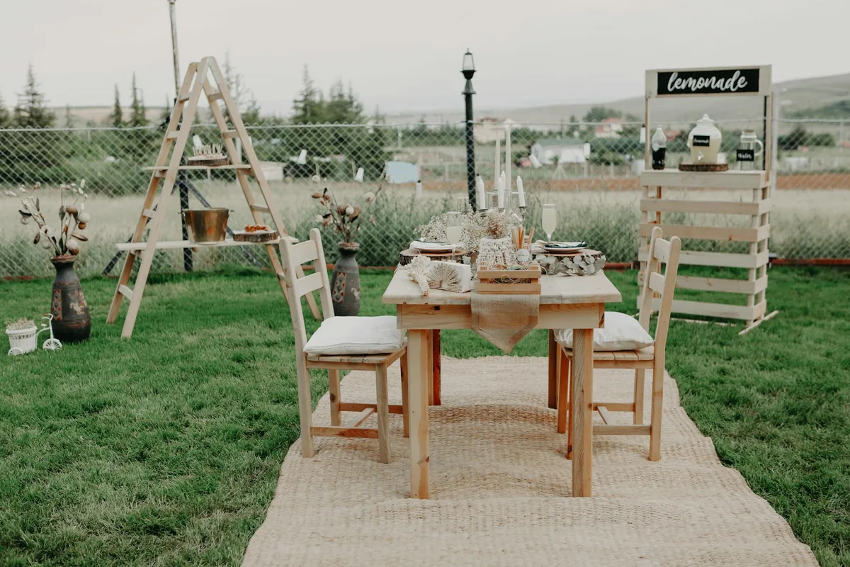 Elegantes Outdoor-Holztisch-Setup mit Limonadenstand für Veranstaltungen