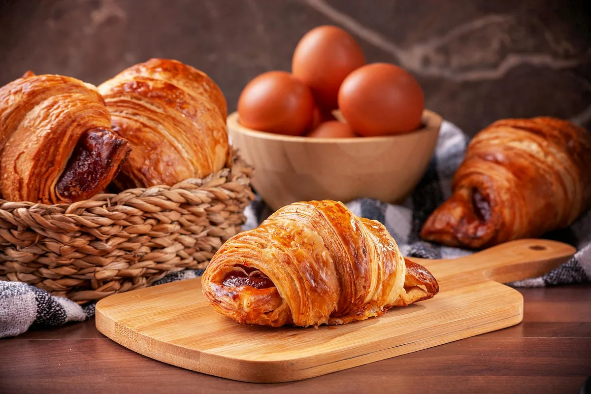 黄金色のクロワッサンと新鮮卵の朝食シーン