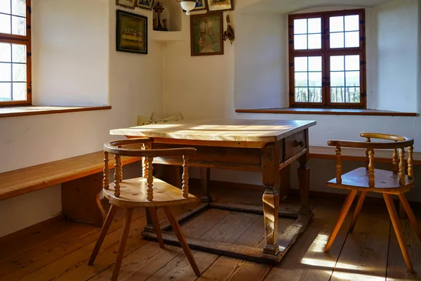 Sunlit rustic farmhouse interior featuring wooden furniture and warm ambiance, ideal for cozy settings.