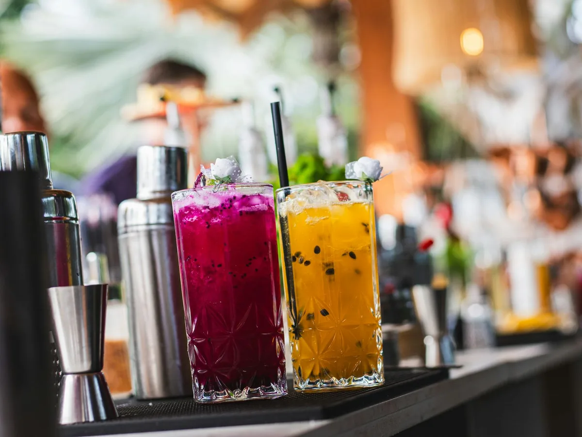 Cocktails violets et jaunes vibrants sur un comptoir de bar pour une célébration estivale