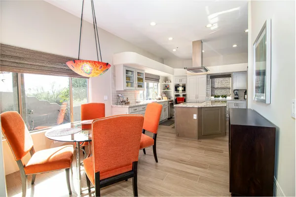 Cucina e sala da pranzo contemporanee con sedie arancioni vivaci e arredamento elegante