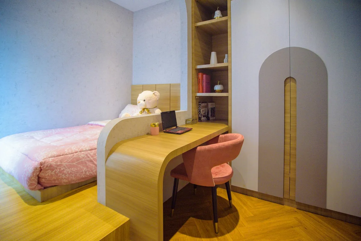 Modernes, gemütliches Schlafzimmer mit Schreibtisch, Laptop und rosa Bettwäsche