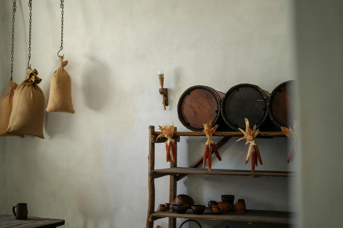 Rustikale Kücheneinrichtung mit hängenden Jutesäcken und Holzbrettern mit getrocknetem Mais