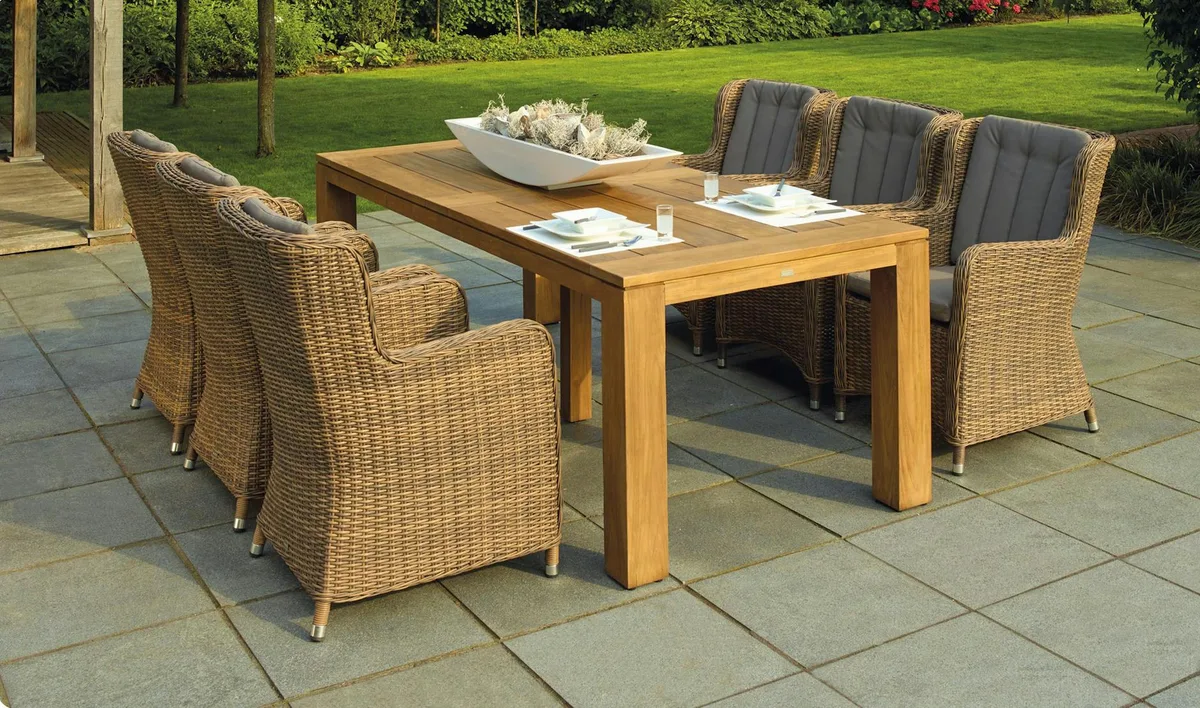 Patio extérieur serein avec fauteuils en rotin et table en bois pour la détente