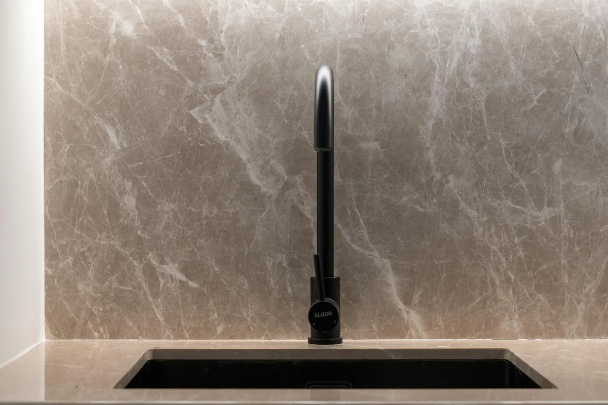 Lavello cucina moderno con alzatina in marmo e rubinetto nero