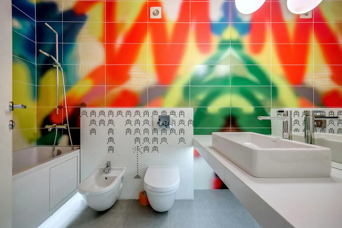 Bagno vivace con piastrelle colorate, vasca, lavandino e water