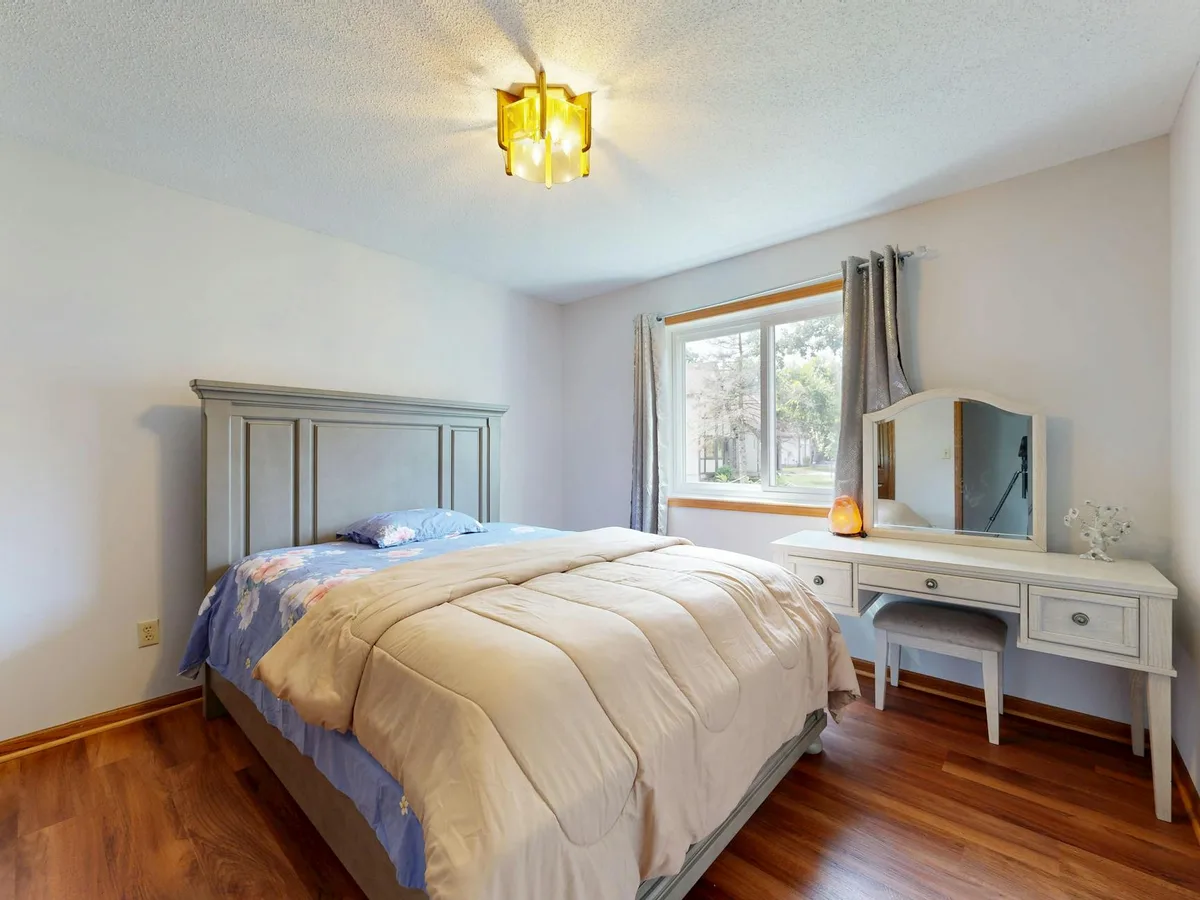 Camera da letto luminosa con letto comodo e mobili in legno con luce naturale