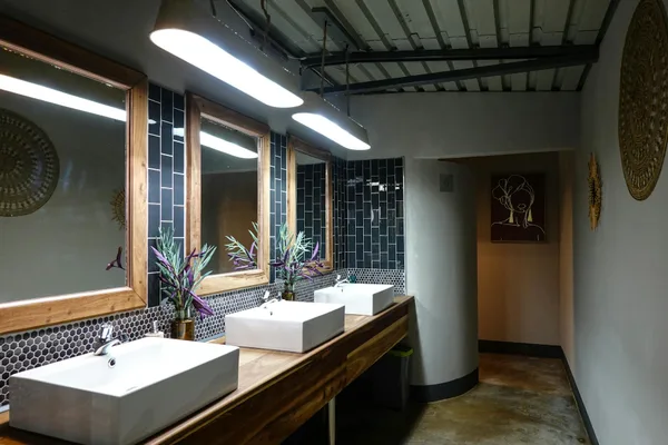 Modernes Badezimmer mit stilvollen Waschbecken, Spiegeln und Dekorationselementen