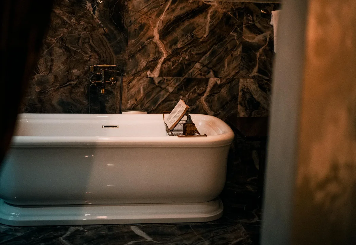 Luxuriöses Badezimmer mit klassischer weißer Badewanne und eleganten Marmorwänden