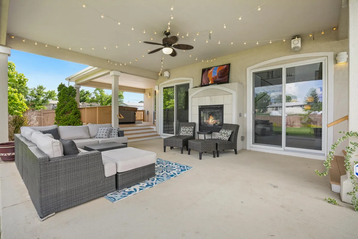 Patio extérieur luxueux avec cheminée cosy, mobilier moderne et guirlandes lumineuses pour un espace détente