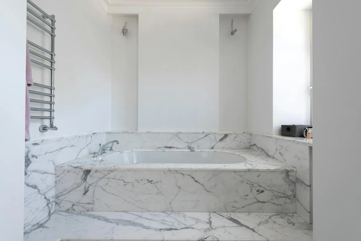 Modernes Badezimmer mit Marmor-Badewanne und Chromarmaturen