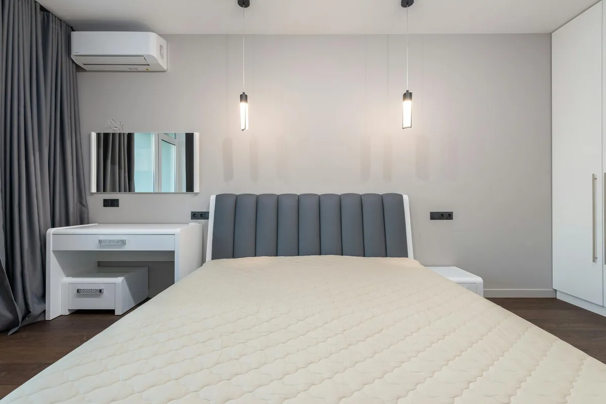 플러시 침대와 펜던트 조명이 있는 슬릭한 미니멀 침실 디자인