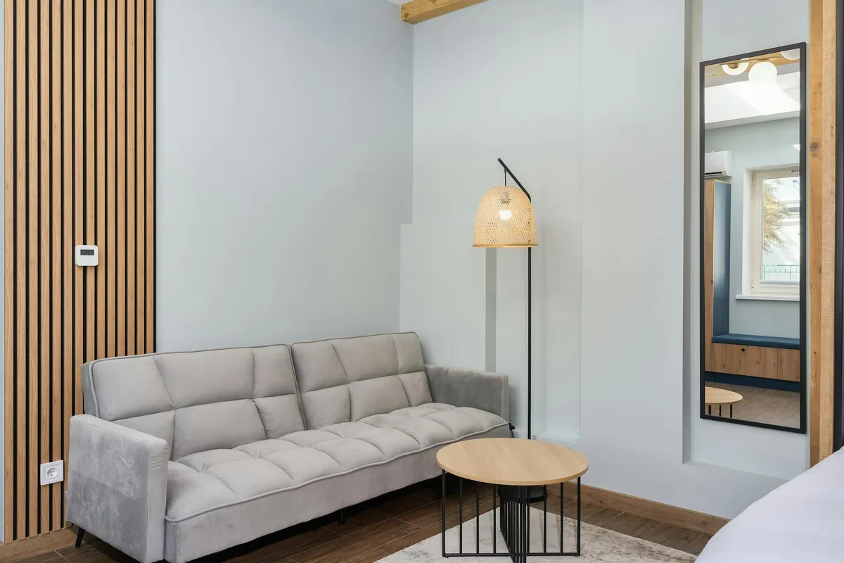 Salon chic avec canapé gris, déco bois et lumière tamisée