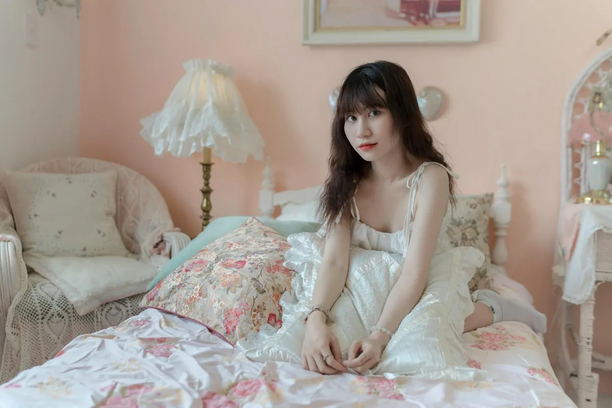 Femme dans une chambre pastel avec coussins moelleux et décoration vintage