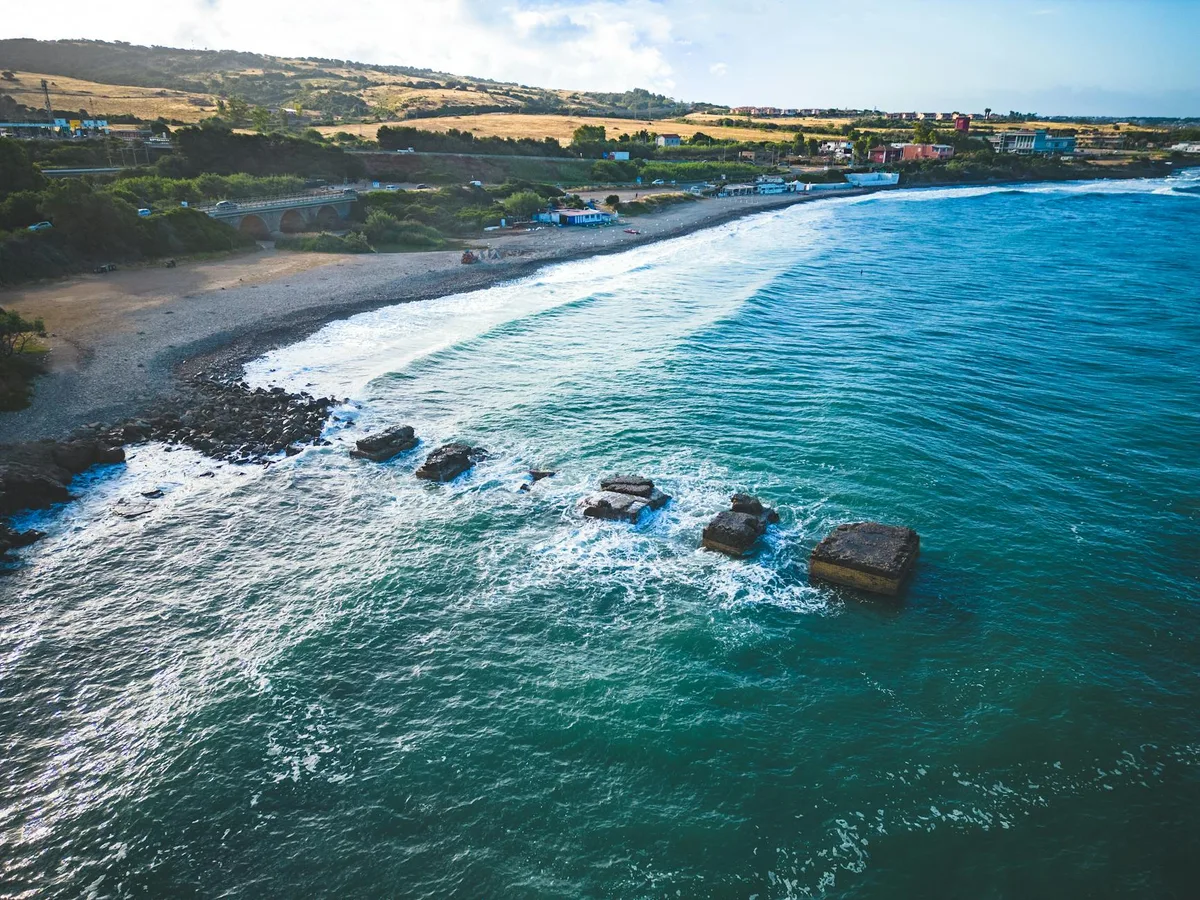 Scatto aereo della costa serena con onde e spiaggia durante il giorno