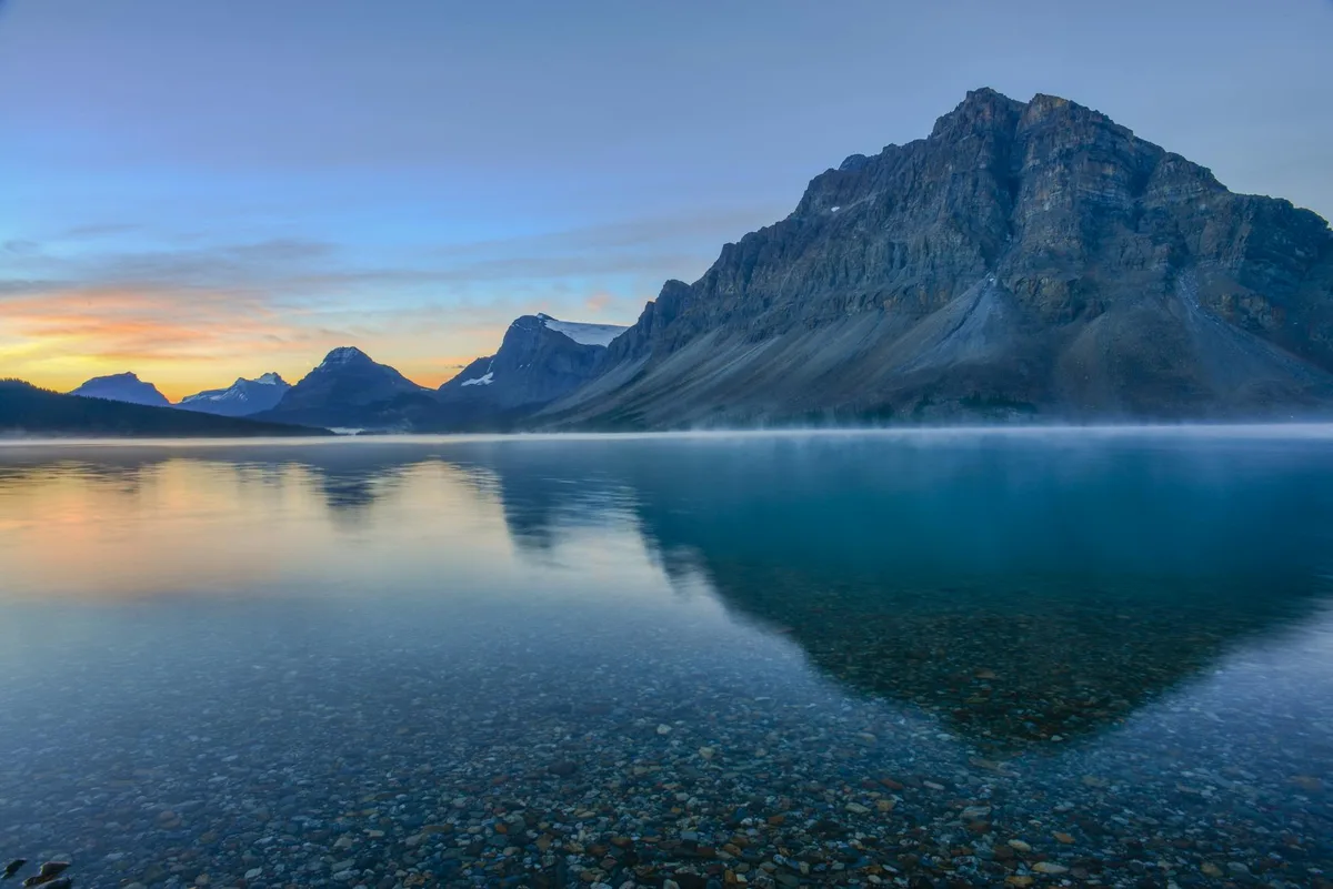 Alba mozzafiato sul Bow Lake con riflessi montani nel Parco Nazionale di Banff, Alberta, Canada