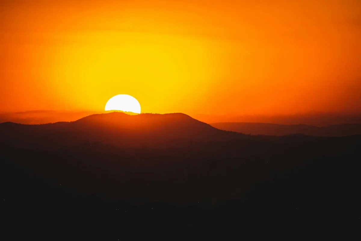 Tramonto mozzafiato sulle montagne brasiliane con bagliore arancione all'orizzonte