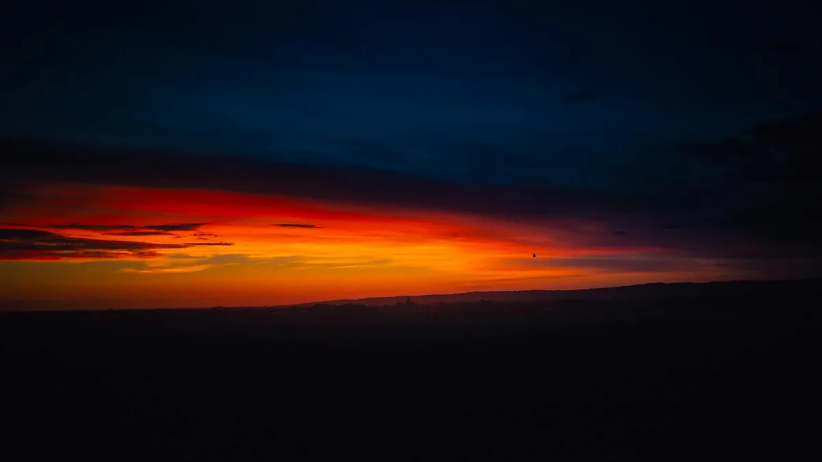 Tramonto vivido con tonalità arancioni e blu sul paesaggio polacco