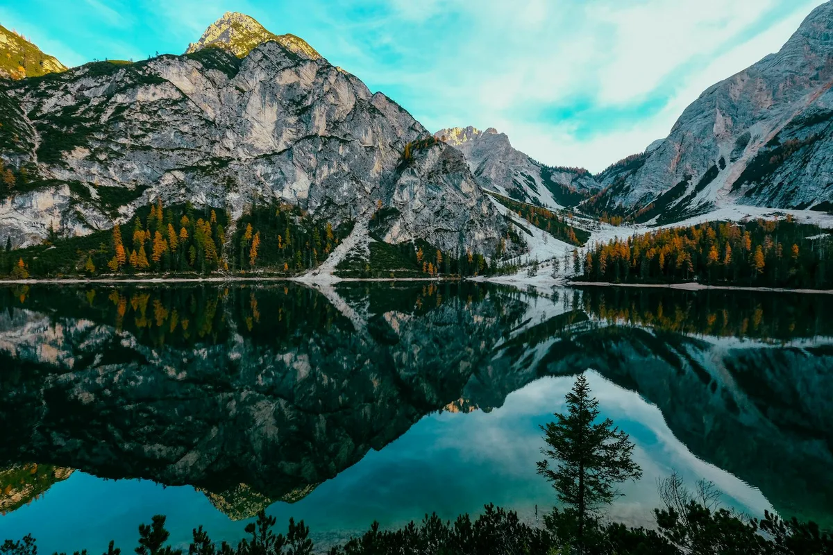 Vista mozzafiato del Lago di Braies con riflesso montano nelle Alpi Italiane, ideale per amanti della natura.