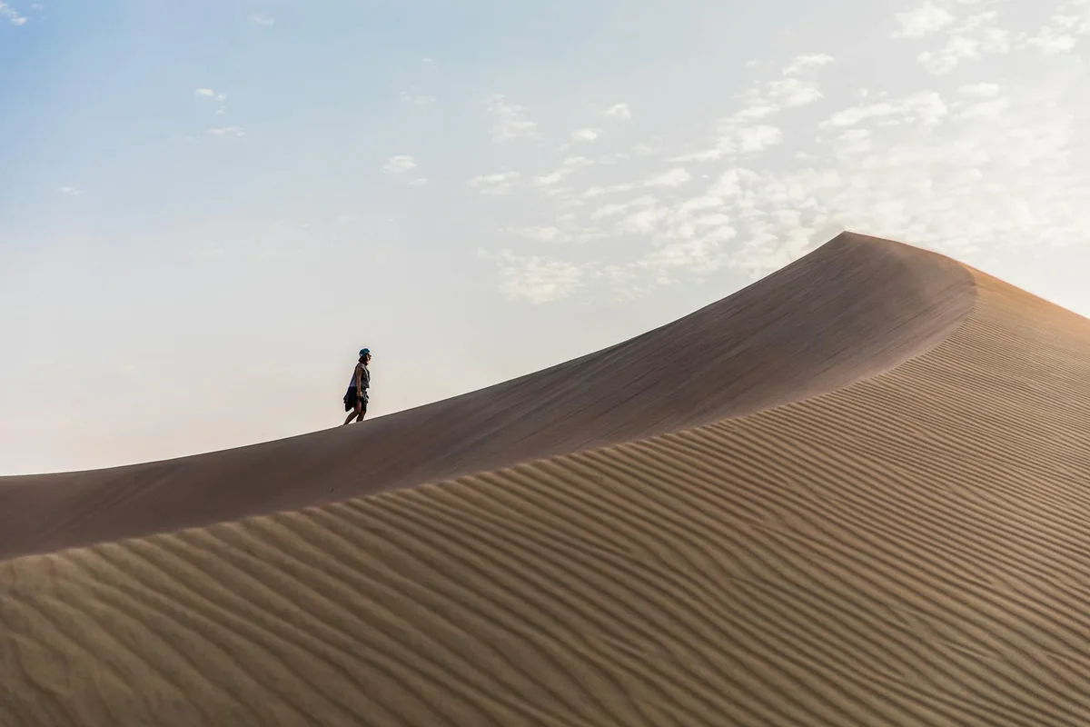 Voyageur solitaire explorant les dunes de sable majestueuses de Huacachina, Pérou