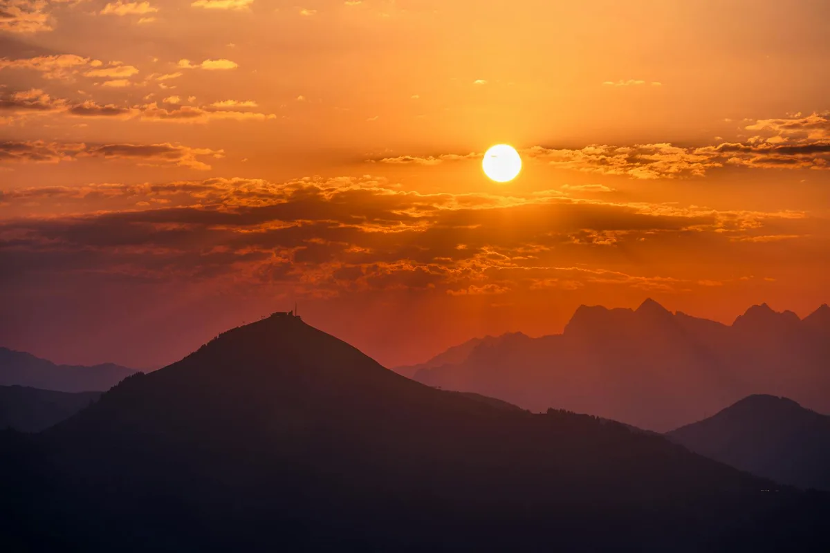 Malerischer Sonnenuntergang über silhouettenhaften Bergen und lebhaften Himmeln