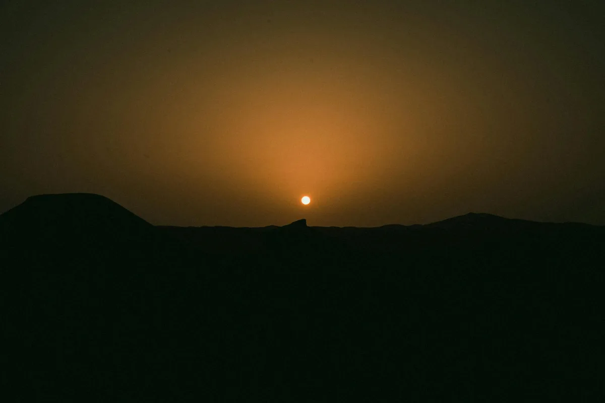 Tramonto tranquillo sul paesaggio desertico di Ouargla, Algeria, con orizzonte arancione caldo