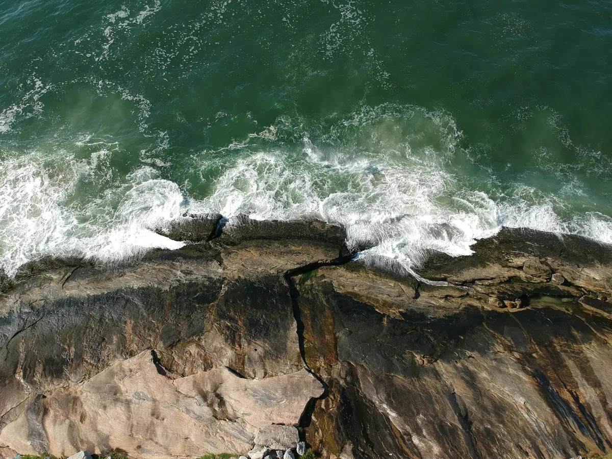 브라질 구아루자 해안 절벽에 부서지는 파도의 공중 전망