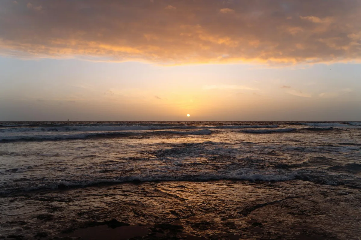 Schöner Sonnenuntergang über den Wellen der Kanarischen Inseln mit ruhiger Küstenansicht