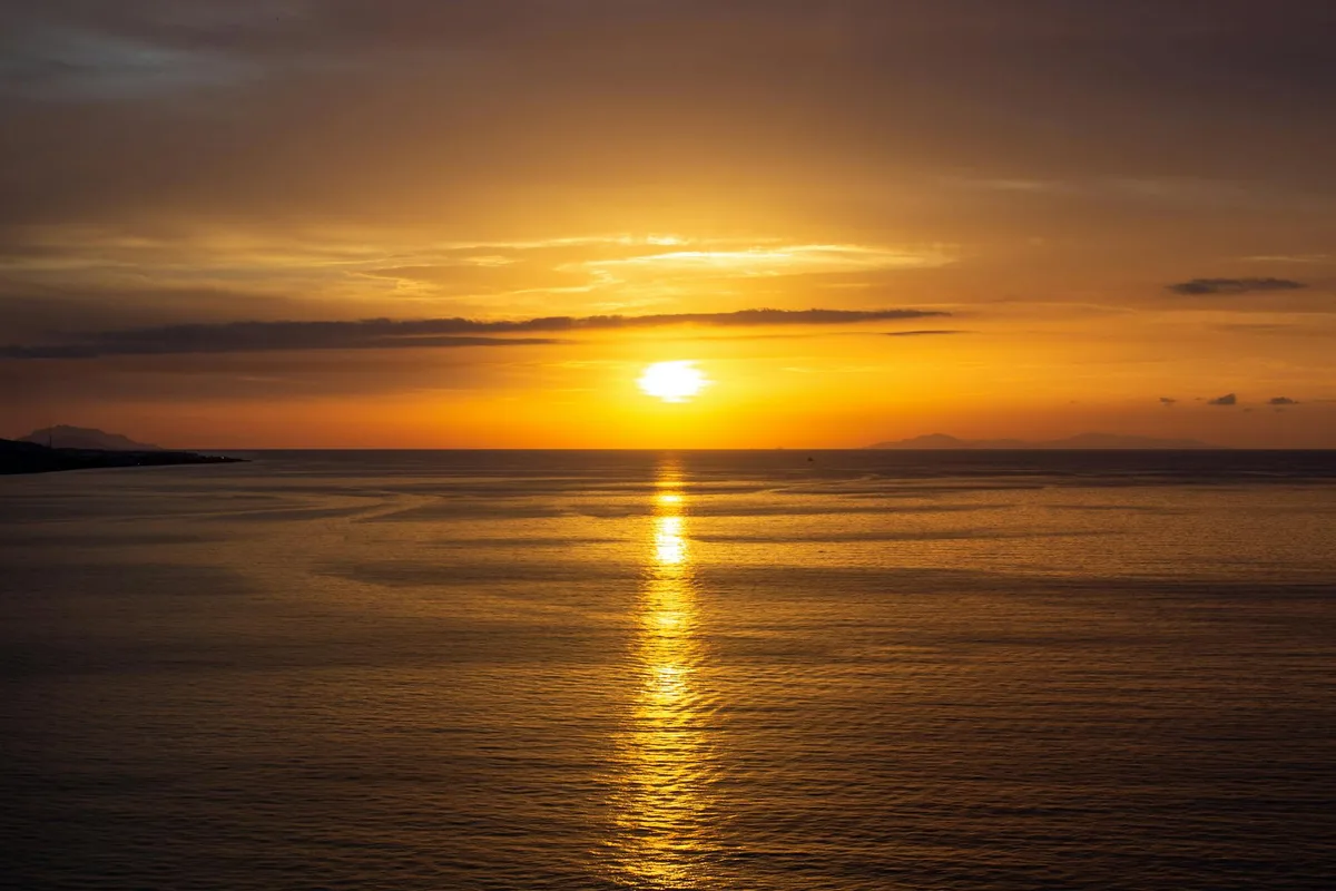 황금빛 노을이 반사된 고요한 바다의 선셋 팔레트