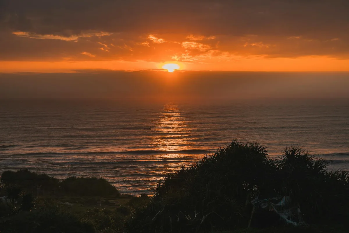 Atemberaubender oranger Sonnenuntergang über ruhigem Ozean – Wasserreflexion