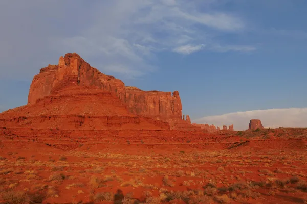 Panorama mozzafiato delle formazioni rocciose rosse sotto un cielo azzurro a Monument Valley