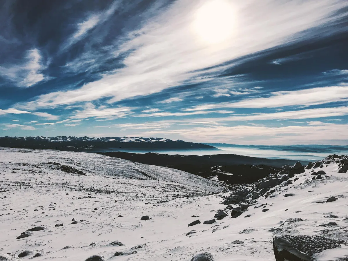 Atemberaubende Aussicht auf schneebedeckte Berge unter hellem Himmel in Bulgarien