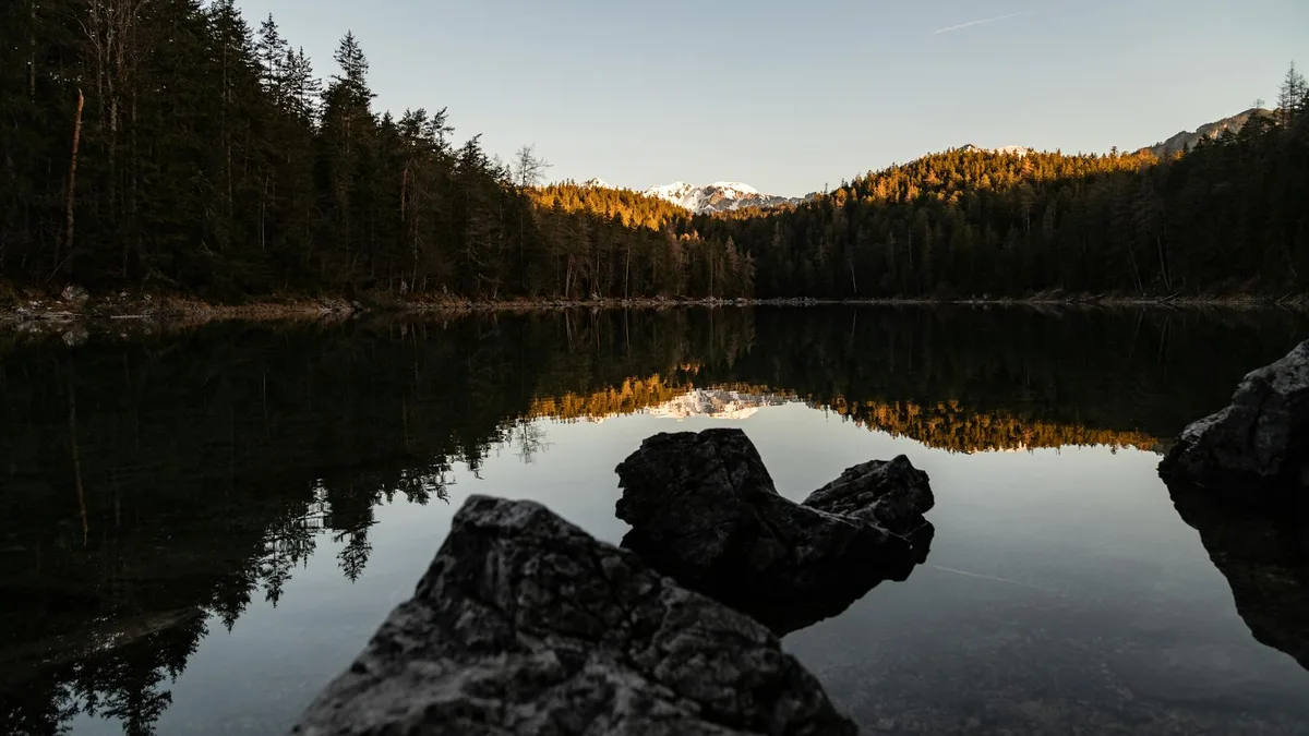 Riflesso mozzafiato del tramonto sulle montagne alpine nel Lago Eibsee, Baviera.