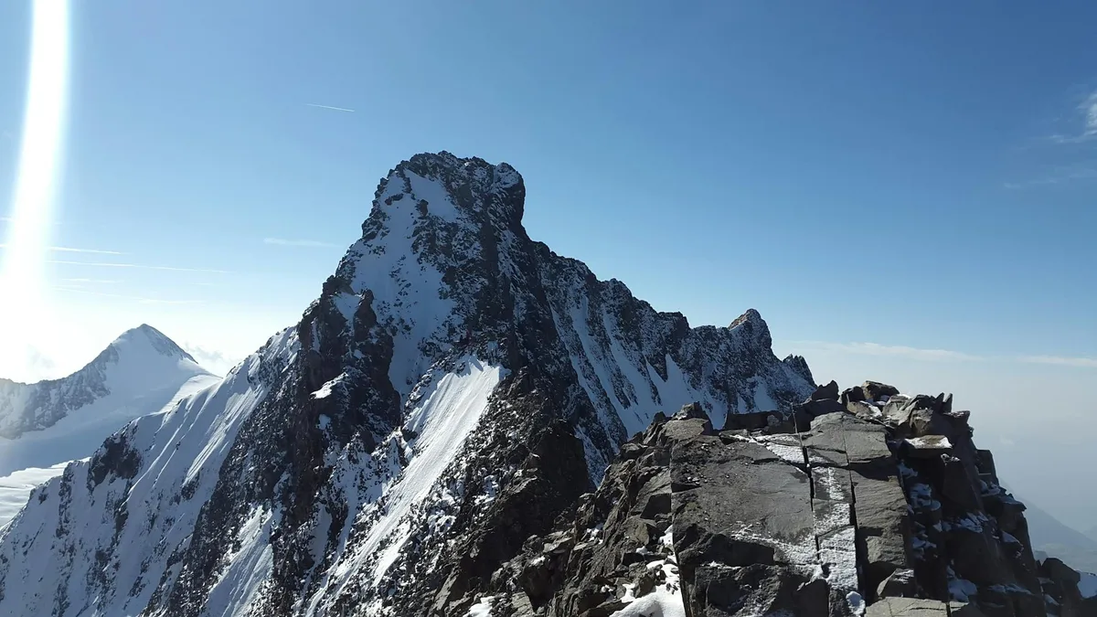 Vista cativante de pico de montanha coberto de neve sob céu azul claro
