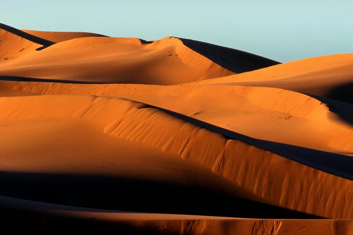 Fesselnder Blick auf die sonnenbeschienenen Sanddünen in M'Hamid El Ghizlane, Marokko, tagsüber